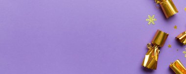 Renkli arka planda parlak konfetileri olan Noel krakerleri, üst görünüm, boşluk kopyala.