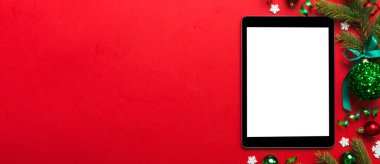 Digital tablet mock up with rustic Christmas decorations for app presentation top view with empty space for you design. Christmas online shopping concept. Tablet with copy space on colored background.