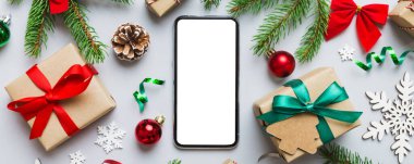 Digital phone mock up with rustic Christmas decorations for app presentation top view with empty space for you design. Christmas online shopping concept. Tablet with copy space on colored background.