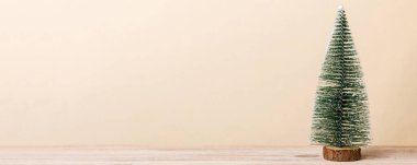 One small Christmas tree on colored background. new year decoration with copy space.