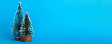 One small Christmas tree on colored background. new year decoration with copy space.