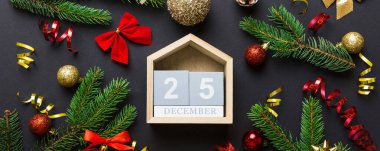Christmas calendar 25 december. Christmas gift, fir branches, pine cones. Flat lay, top view. New Year decorations on a colored background.