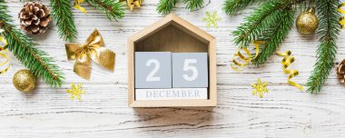 Christmas calendar 25 december. Christmas gift, fir branches, pine cones. Flat lay, top view. New Year decorations on a colored background.