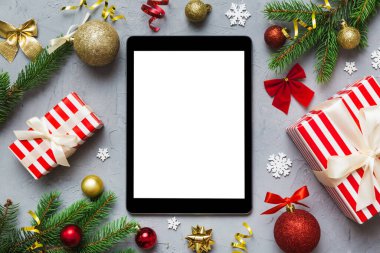 Digital tablet mock up with rustic Christmas decorations for app presentation top view with empty space for you design. Christmas online shopping concept. Tablet with copy space on colored background.