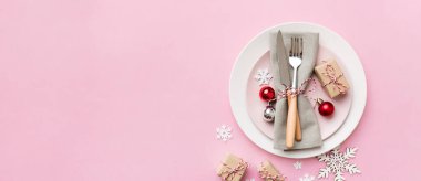 Noel süsleri, tabaklar, inekler, çatallar ve kaşıklarla Noel sofrası. Noel tatili geçmişi. Kopyalama alanı olan üst görünüm.