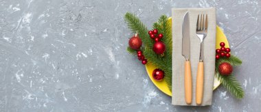 Noel süsleri, tabaklar, inekler, çatallar ve kaşıklarla Noel sofrası. Noel tatili geçmişi. Kopyalama alanı olan üst görünüm.