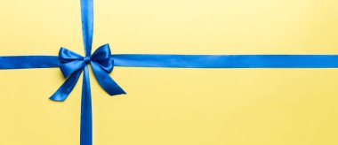 Mor kurdelenin üst görüntüsü yuvarlandı ve pembe fiyonk renkli arka planda izole edildi. Kopyalama alanı olan düz.