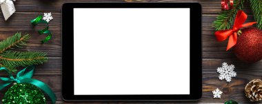 Digital tablet mock up with rustic Christmas decorations for app presentation top view with empty space for you design. Christmas online shopping concept. Tablet with copy space on colored background.