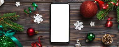 Digital phone mock up with rustic Christmas decorations for app presentation top view with empty space for you design. Christmas online shopping concept. Tablet with copy space on colored background.