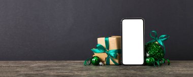 Digital phone mock up with rustic Christmas decorations for app presentation with empty space for you design. Christmas online shopping concept. Tablet with copy space on colored background.