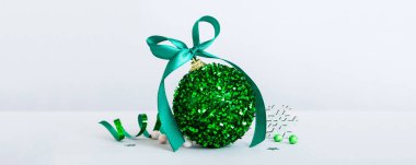 Christmas ball on colored background. decoration bauble with ribbon bow with copy space.