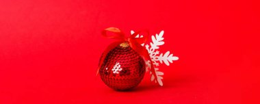 Christmas ball on colored background. decoration bauble with ribbon bow with copy space.