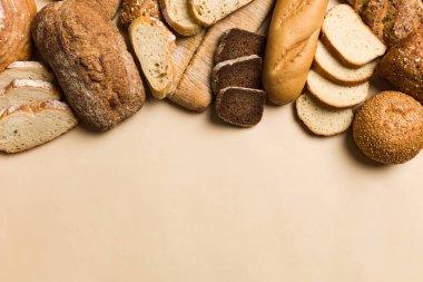Ev yapımı doğal ekmek. Arka plan olarak farklı taze ekmek türleri, kopya alanı ile üst görünüm.