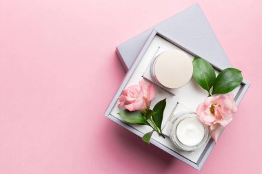 Kozmetik ürünleri ve ahşap arka planda güzel güller olan kompozisyon. Uzayı kopyala, düz yat.