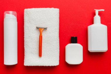 Tıraş Adam seti. Traş makinesi, havlu, losyon ve renkli arka planda tıraş köpüğü. Erkekler banyo aksesuarları üst görünüm.