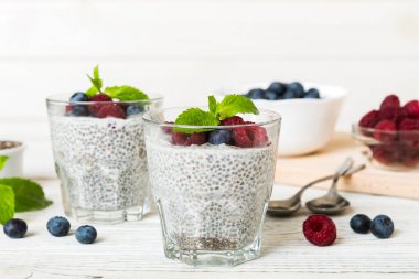 Sağlıklı kahvaltı ya da sabah chia tohumlu vanilyalı puding ahududu ve böğürtlen, vejetaryen gıda, diyet ve sağlık konsepti. Ahududu ve yabanmersinli Chia pudingi..