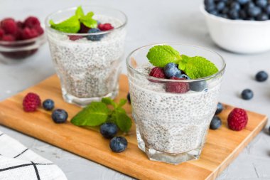 Sağlıklı kahvaltı ya da sabah chia tohumlu vanilyalı puding ahududu ve böğürtlen, vejetaryen gıda, diyet ve sağlık konsepti. Ahududu ve yabanmersinli Chia pudingi..