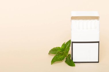 Pack of menthol cigarettes and fresh mint on colored table, Menthol cigarettes top view flat lay. clipart