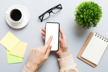 Mesajınız veya bilgi içeriğiniz için boş bir kopya ekranı olan akıllı telefonları tutan kadın ellerinin üst görünümü. üst görünümde telefon beyaz ekranı kullanan kadın eli.