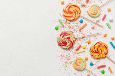 Lezzetli İştah açıcı Parti Aksesuarları Mutlu Yıllar Tatlı. Renkli arkaplanda farklı tipte şekerler, kopyalama alanı. Renkli doğum günü partisi geçmişi.