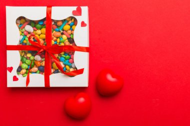 Valentine day composition: sweet candy, with gift boxes with bow and red felt hearts, photo template, background. Top View with copy space.