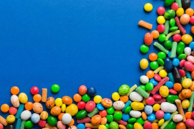 Renkli arka planda karışık renkli şeker koleksiyonu. Düz yerde, üst tarafta. Renkli çikolata kaplı şeker çerçevesi.