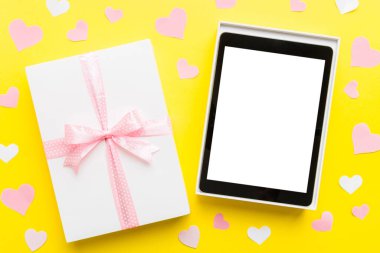 Gift box of open tablet for the holidays with a bow top view.