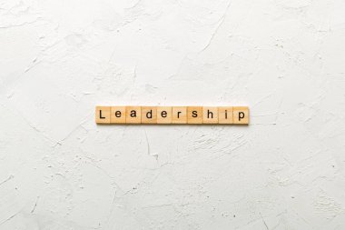 Liderlik kelimesi tahta blokta yazılı. Masada Liderlik metni, konsept.
