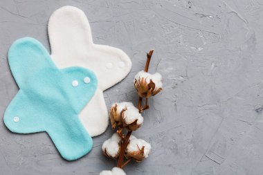 Üzerinde pamuk çiçekleri olan renkli, yeniden kullanılabilir adet pedleri. sıfır atık kadın dönemi konsepti kopya alanı ile üst görünüm.