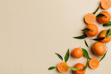 Renkli arkaplanda yeşil yaprakları, üst görünümü, metin için alanı olan bir sürü olgun mandalina..