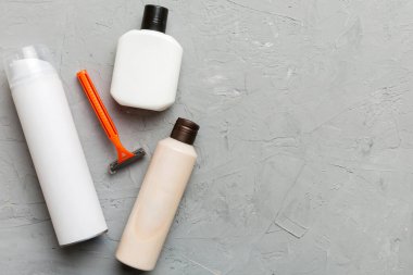 Tıraş Adam seti. Traş makinesi, havlu, losyon ve renkli arka planda tıraş köpüğü. Erkekler banyo aksesuarları üst görünüm.