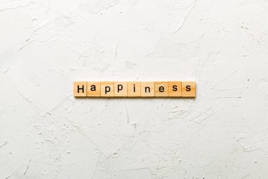Tahta blokta yazan mutluluk kelimesi. Masada mutluluk metni, konsept.