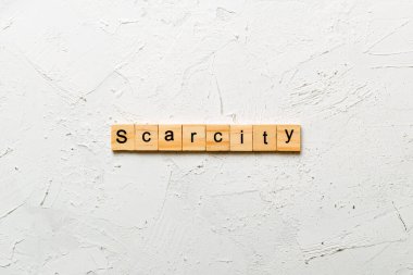 Tahta blokta nadir bir kelime yazıyor. Çimento masasındaki kıtlık metni desing, konsept için.