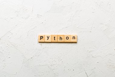 Tahta blokta piton kelimesi yazılı. Python metni tablo üzerinde, konsept.