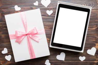 Gift box of open tablet for the holidays with a bow top view.