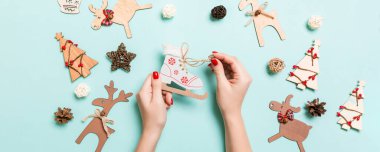 Mavi arka plandaki kadın ellerindeki patenlerin en üst görüntüsü. Noel süsleri. Yeni yıl tatili konsepti.