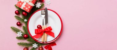 Noel süsleri, tabaklar, inekler, çatallar ve kaşıklarla Noel sofrası. Noel tatili geçmişi. Kopyalama alanı olan üst görünüm.