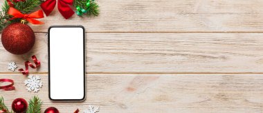 Digital phone mock up with rustic Christmas decorations for app presentation top view with empty space for you design. Christmas online shopping concept. Tablet with copy space on colored background.
