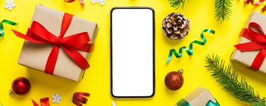 Digital phone mock up with rustic Christmas decorations for app presentation top view with empty space for you design. Christmas online shopping concept. Tablet with copy space on colored background.