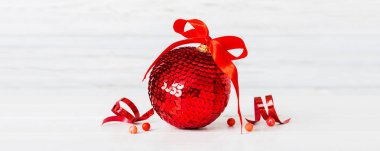 Christmas ball on colored background. decoration bauble with ribbon bow with copy space.