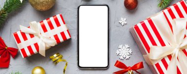 Digital phone mock up with rustic Christmas decorations for app presentation top view with empty space for you design. Christmas online shopping concept. Tablet with copy space on colored background.