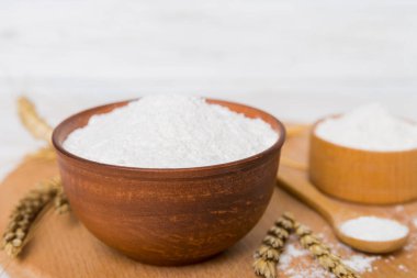 Tahta kasede buğday unu ve renkli arka planda buğday dikenleri. dünya buğday krizi.