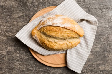 Tahtanın üzerinde beyaz ahşap zemine karşı taze pişmiş ekmek. Kopya alanı olan üst görünüm ekmeği.