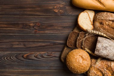 Ev yapımı doğal ekmek. Arka plan olarak farklı taze ekmek türleri, kopya alanı ile üst görünüm.