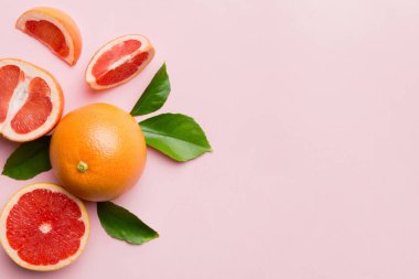 Renkli arka planda sulu greyfurt dilimli taze meyve greyfurdu. Üst Manzara. Uzayı kopyala yaratıcı yaz konsepti. Minimum düzlükte turunçgillerin yarısı kopyalama alanı ile yatar.