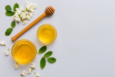 Akasya çiçekli ve yapraklı bal kavanozu. Taze bal üst görünüm düz yatıyordu.