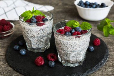 Sağlıklı kahvaltı ya da sabah chia tohumlu vanilyalı puding ahududu ve böğürtlen, vejetaryen gıda, diyet ve sağlık konsepti. Ahududu ve yabanmersinli Chia pudingi..