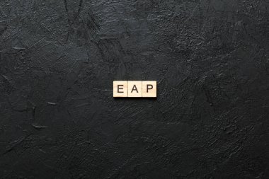 EAP word written on wood block. employee assistance program text on table, concept.
