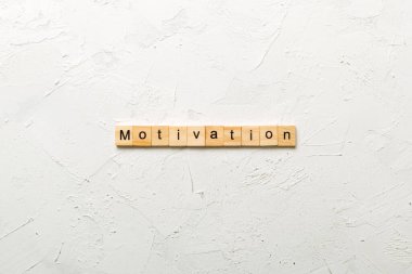 Tahta blokta yazan motivasyon kelimesi. Deksing, konsept için çimento masadaki motivasyon metni.