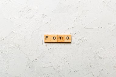 Tahta blokta yazılı bir kelime. fomo metin masa üzerinde, konsept.